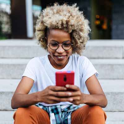 A woman on her phone sitting on stairs outside