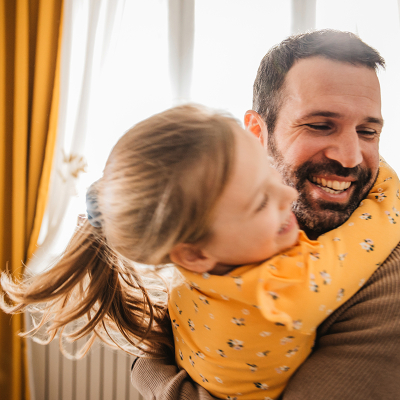 A man playing with a child at home